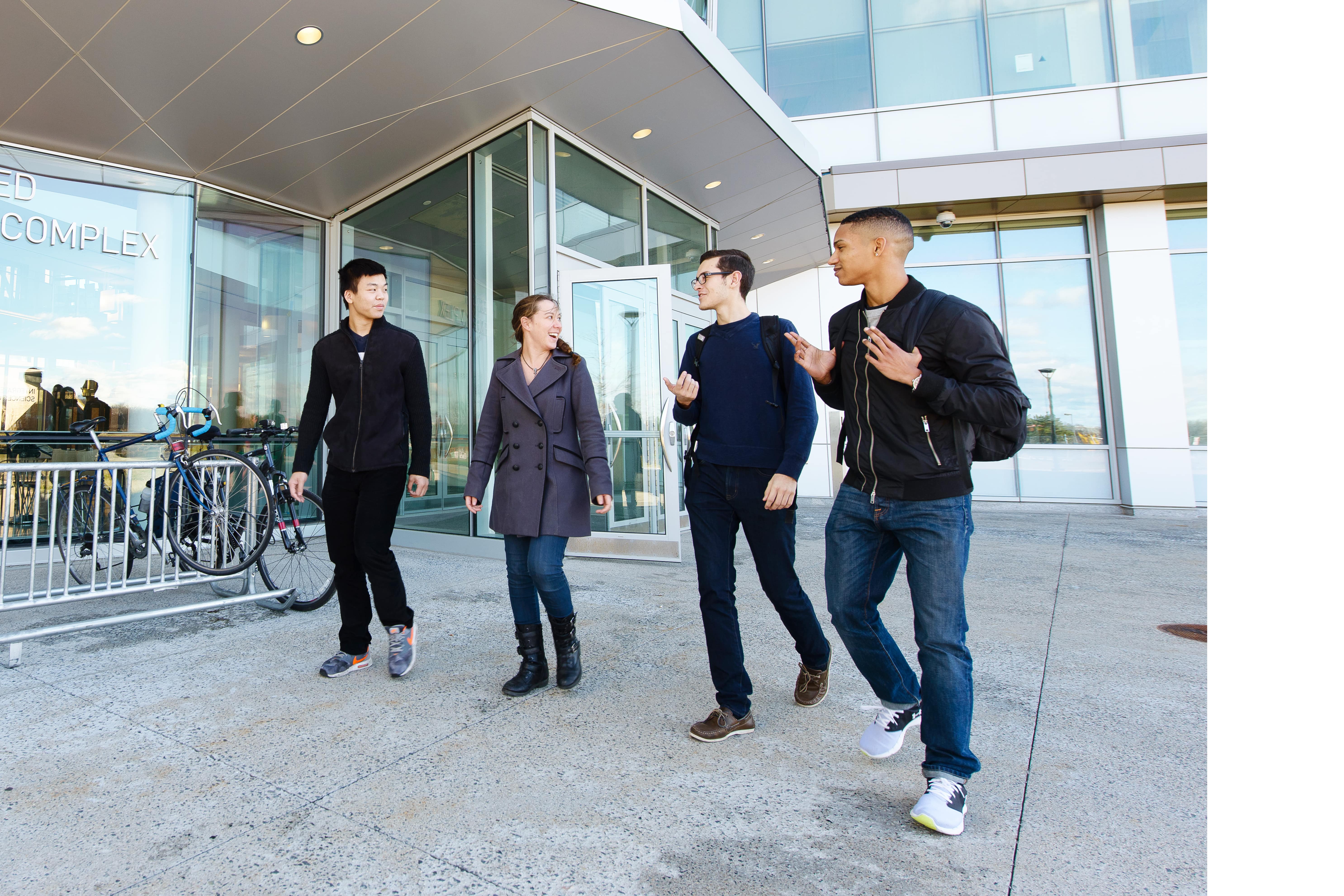 Four students walk in front of Integrated Sciences Complex