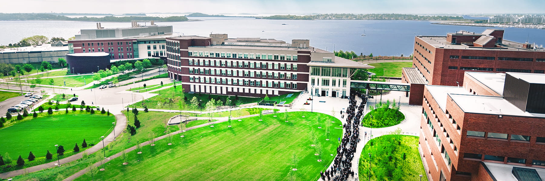 An aerial view of the UMass Boston Quad and the Campus Center with Boston Harbor in the background