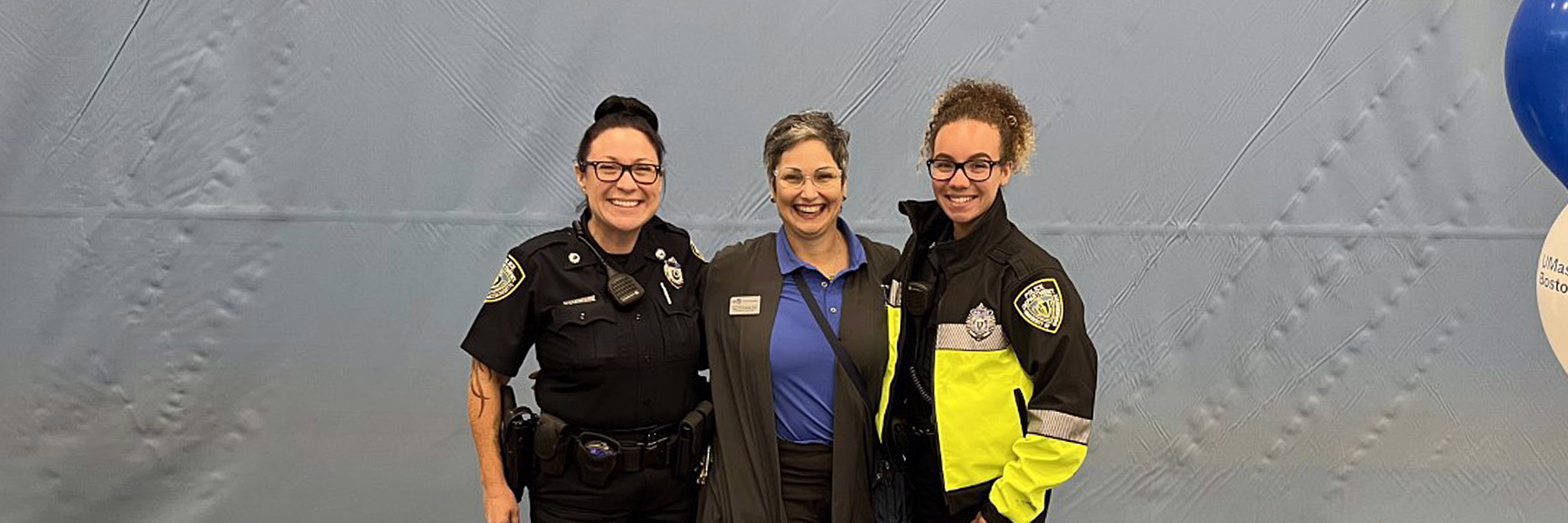 3 security offers pose at an information table indoors.