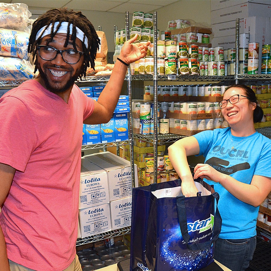 UAccess two students work in supply room with shelves of goods.