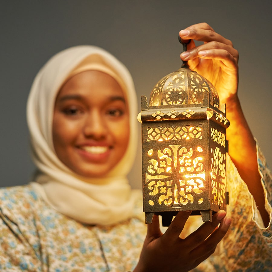 malay hijab with traditional clothing holding arabic lantern celebrating ramadan