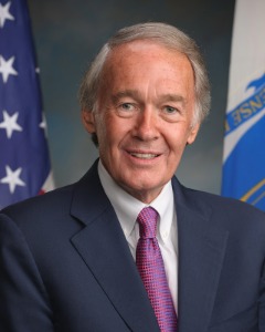 Photo of Senator Edward J. Markey in front of a gray background and the American Flag and Massachusetts State Flag.